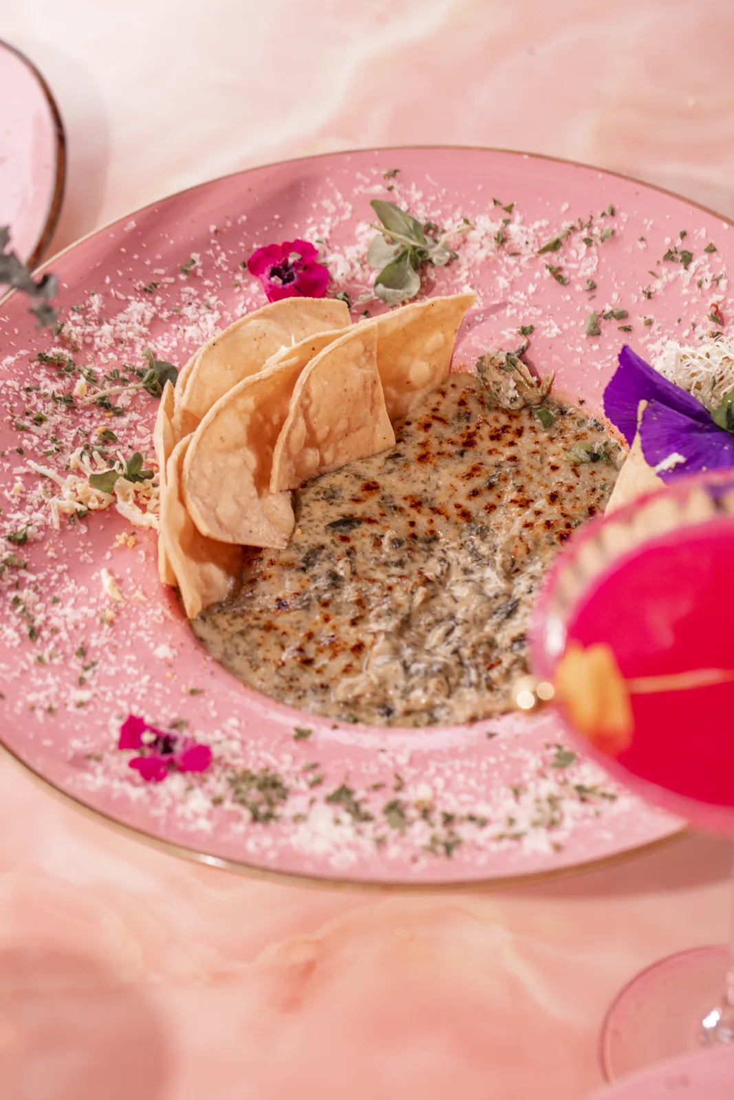 A shareable dish plated at Nigel's, garnished with flowers, on the dockside patio